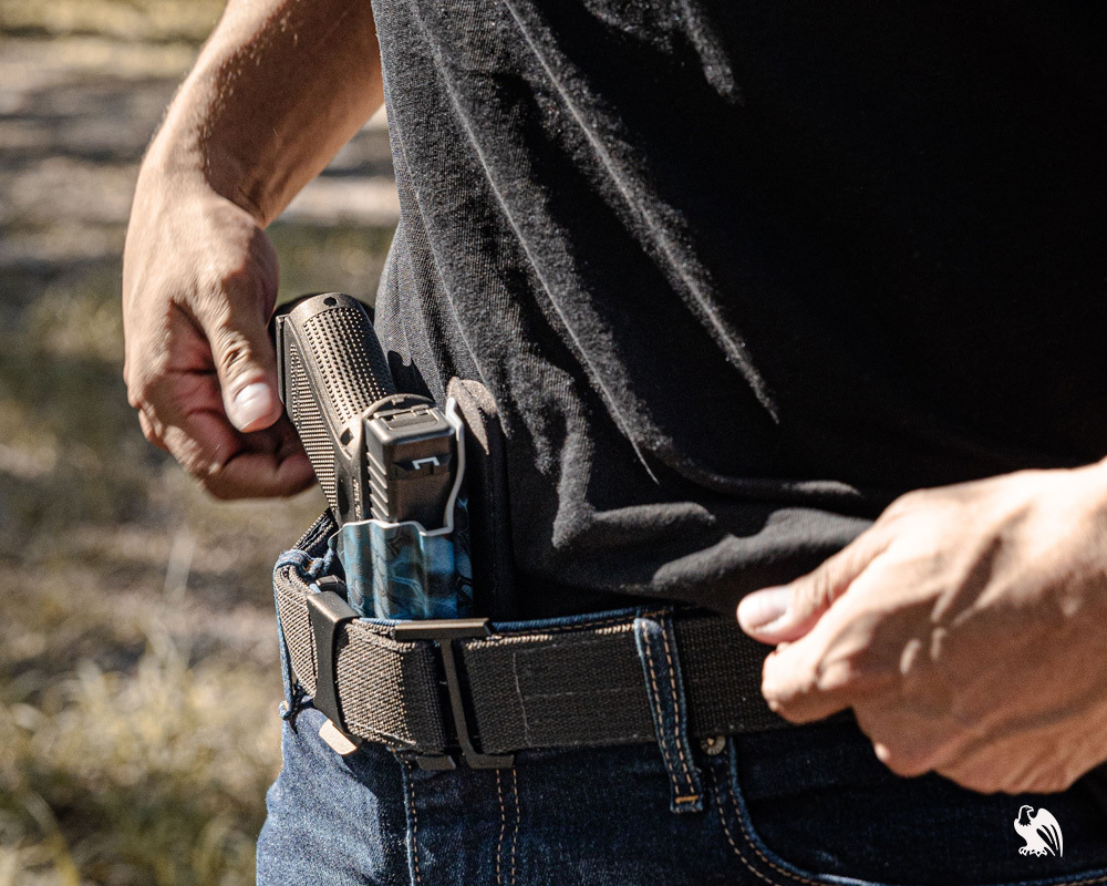 FN Reflex pistol in a Vedder Holsters IWB Kydex holster, worn with a sturdy belt for secure, comfortable concealed carry in a casual outdoor setting.