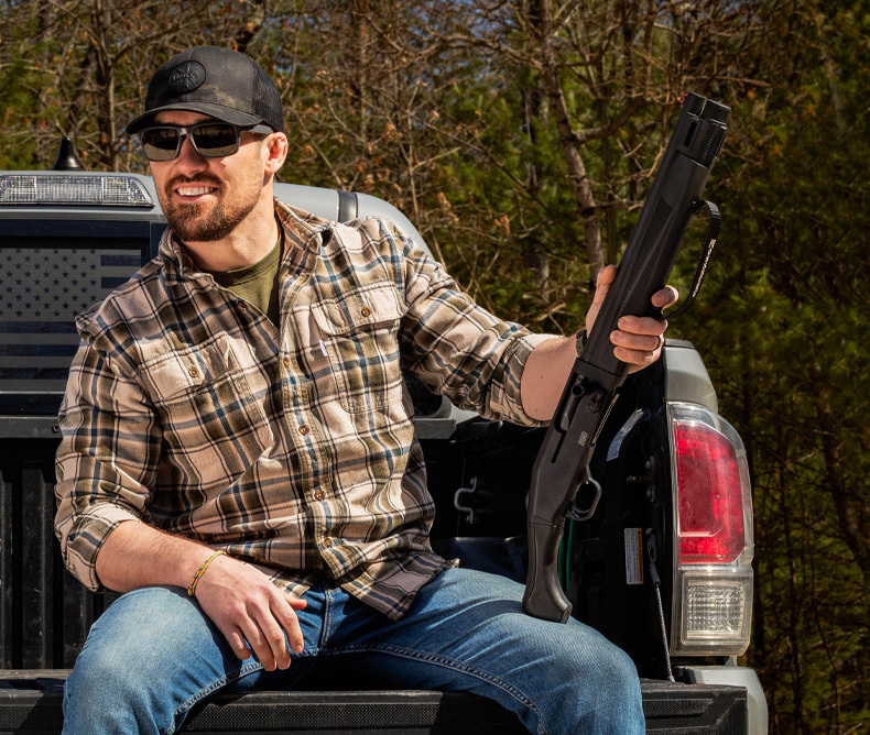 Man holding the new Mossberg 990 AfterShock Shotgun