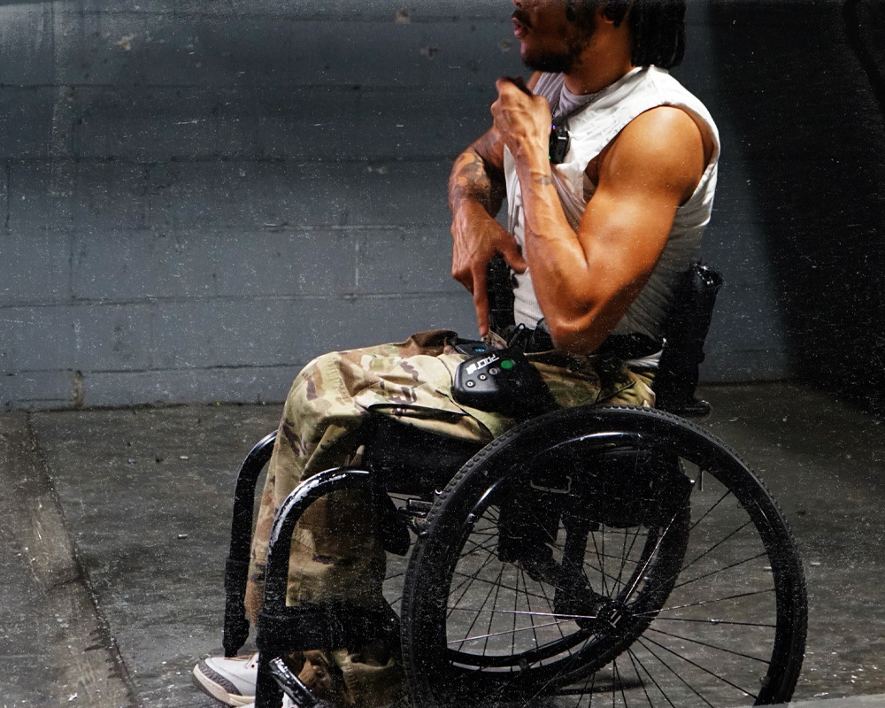 Wheelchair user practicing concealed carry techniques of drawing his gun from an appendix carry.
