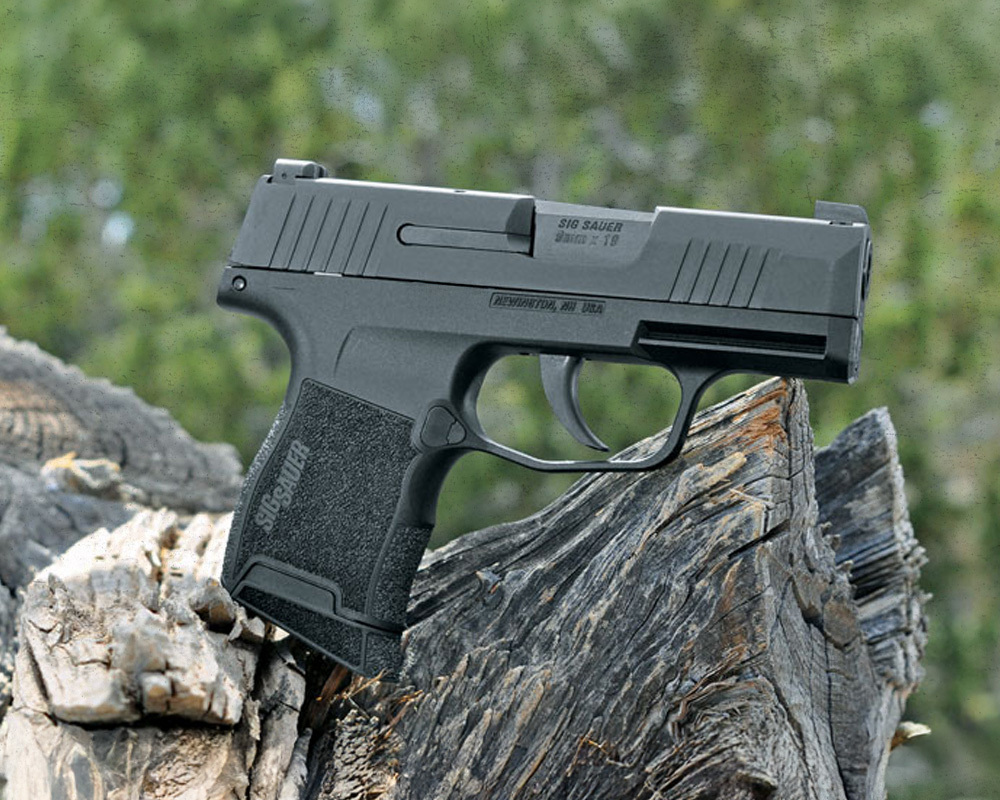 Sig Sauer P365 handgun staged photography on top of a tree trunk.
