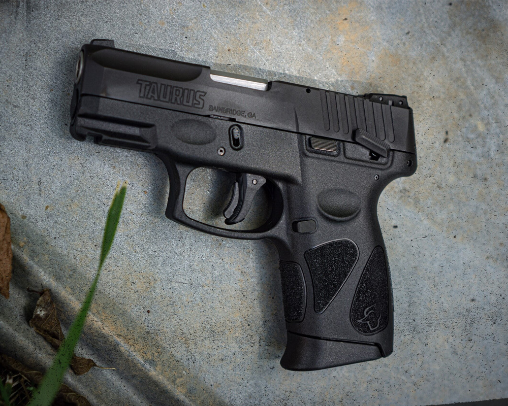 Taurus G2C handgun staged photography, laying on top of cement.