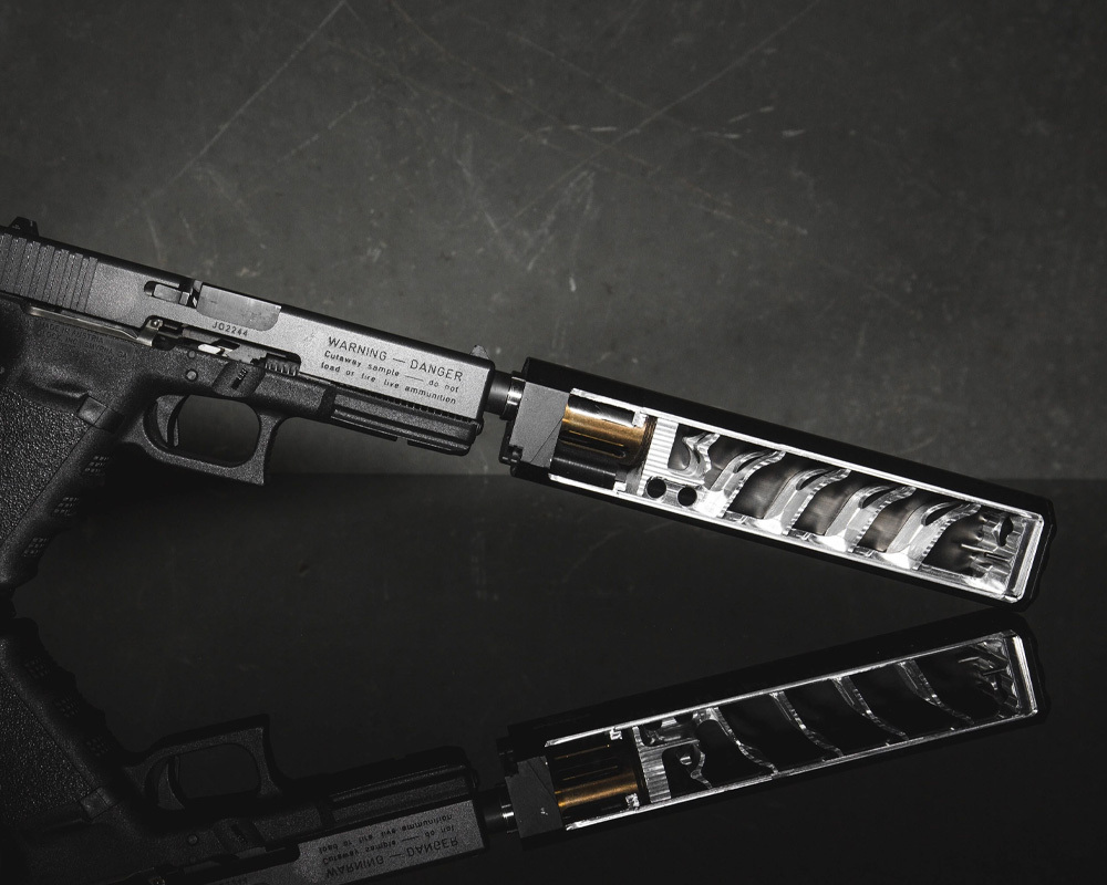 Handgun with a silencer or suppressor but its split in half so we can see how ititss contructed inside. 