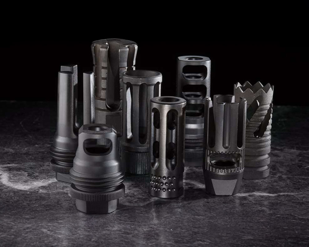 Multiple muzzle devices next to each other of different shapes and sizes.