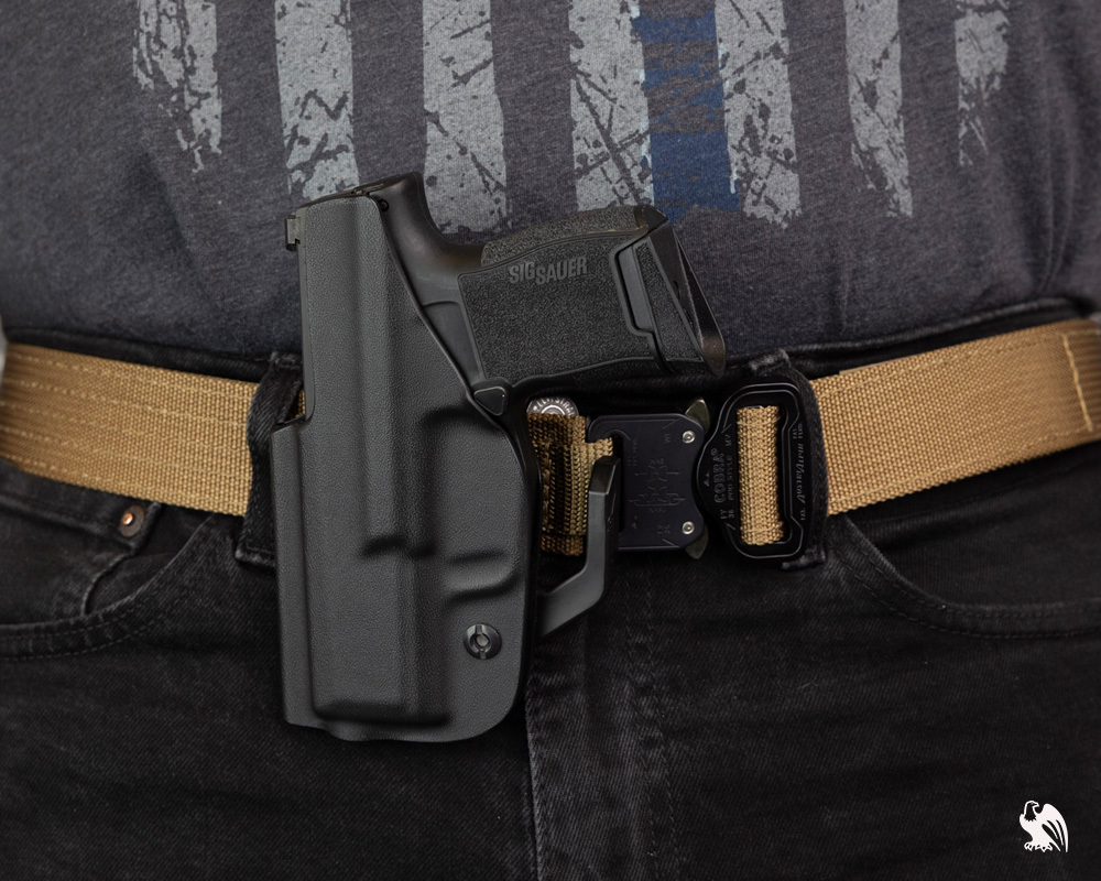 Vedder IWB Kydex holster worn outside the waistband on a tan tactical belt, illustrating why IWB holsters aren't designed for OWB carry.