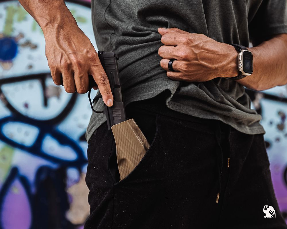 A man draws a pistol from a Vedder Holsters pocket holster, demonstrating deep concealment and quick access from casual everyday attire.