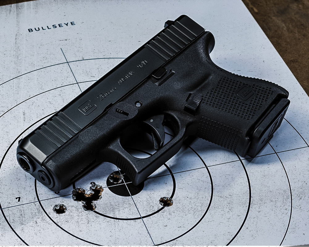 Glock 26 Gen4 9mm pistol on a bullseye target with tight shot groupings, showcasing accuracy and compact concealed carry performance.