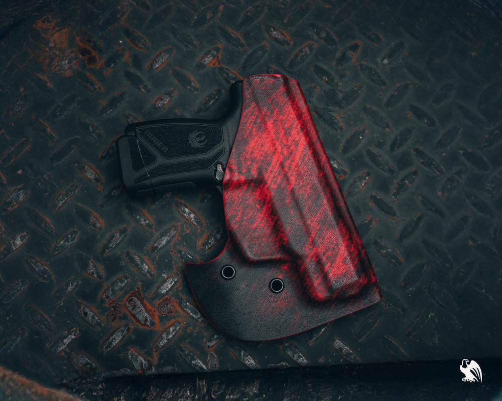 ed and black Vedder Pocket Locker holster designed for your everyday use, displayed on a steel surface to highlight its compact, durable design for pocket carry.