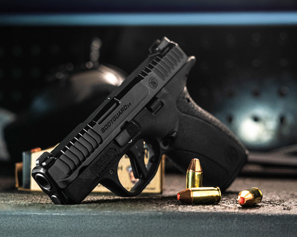 Smith & Wesson Bodyguard 2.0 pistol with hollow-point ammo on a bench, ideal for concealed carry and everyday self-defense.