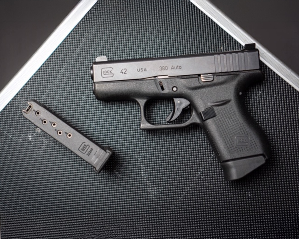Glock 42 chambered in .380 Auto with a single-stack magazine, shown on a textured surface, popular for pocket carry and concealed self-defense.