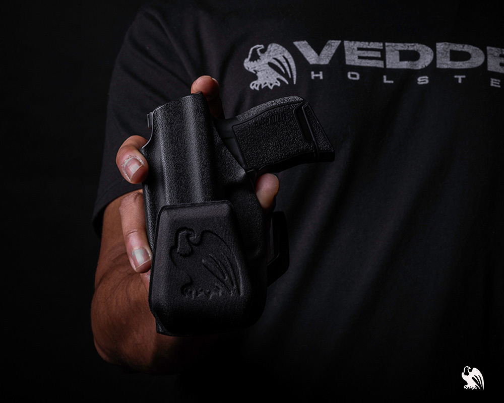 Man holding a Lighttuck holster with the holster wedge from Vedder Holsters.