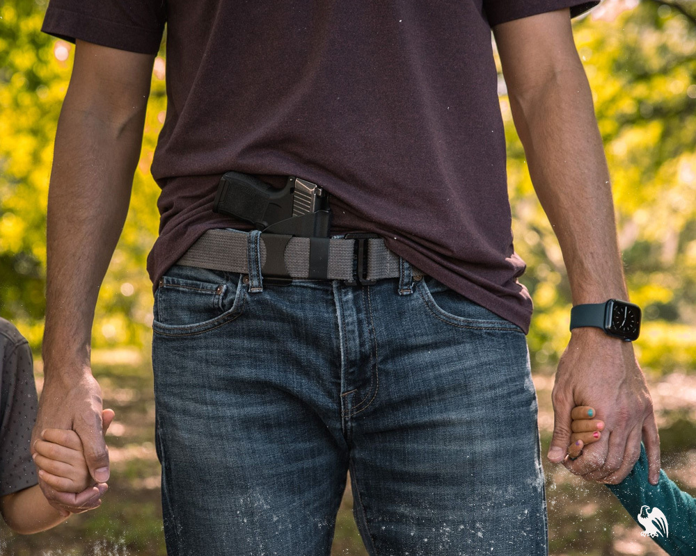 Man carrying his IWB holster from Vedder Holster while holding the hands of his two kids. 