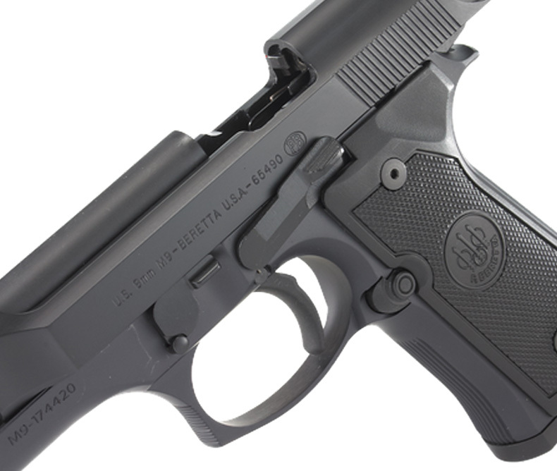 Close-up of a Beretta M9 9mm semi-automatic pistol showing the slide, safety lever, trigger guard, and grip texture, with clear engraving of model and serial number, deal for firearm comparison guides, military sidearm discussions, or gun safety education.