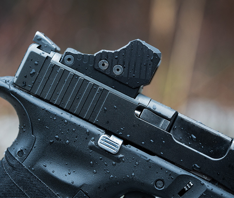 Close up of a slide stop and slide lock release on a handgun. 
