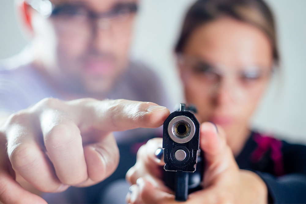 Instructor teaching or giving advice to woman ready to shoot a target