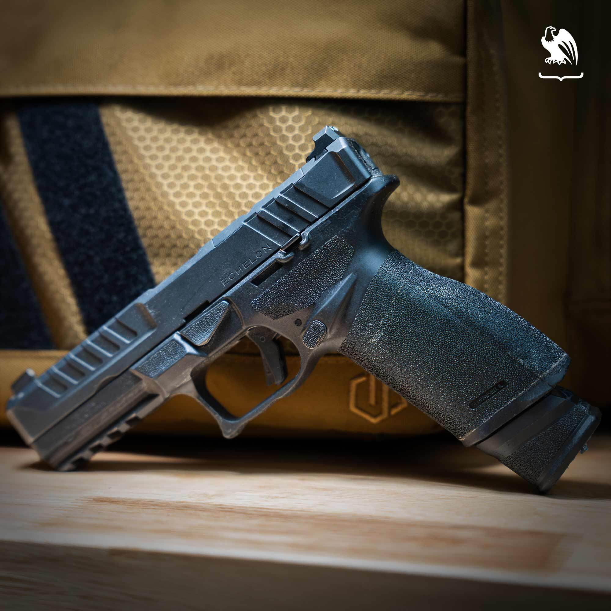 A Springfield Armory Echelon with an extended magazine propped up in front of a tan range bag