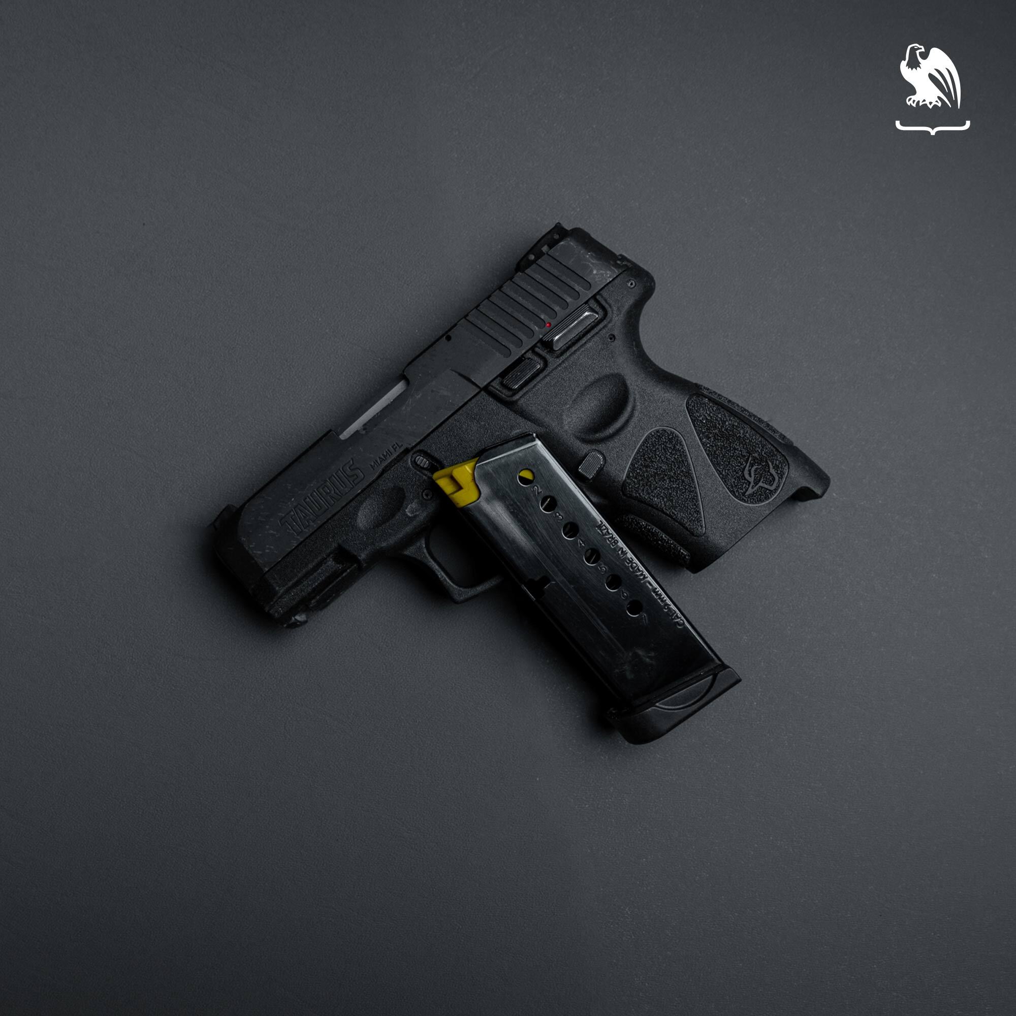 Taurus G2C 9mm compact pistol with detached magazine displayed on gray background