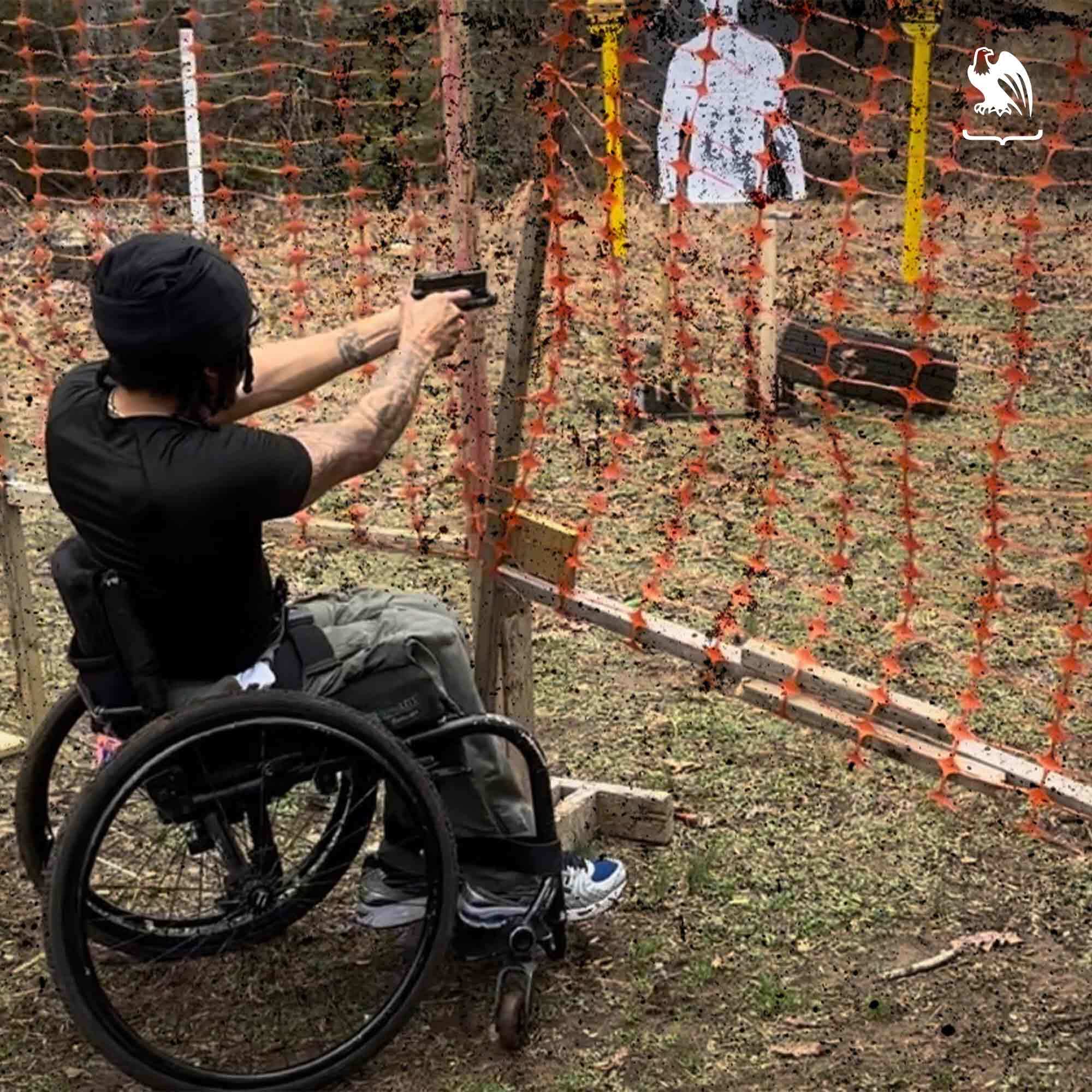 Man on a wheelchair practicing his shooting at a outdoor shooting range.