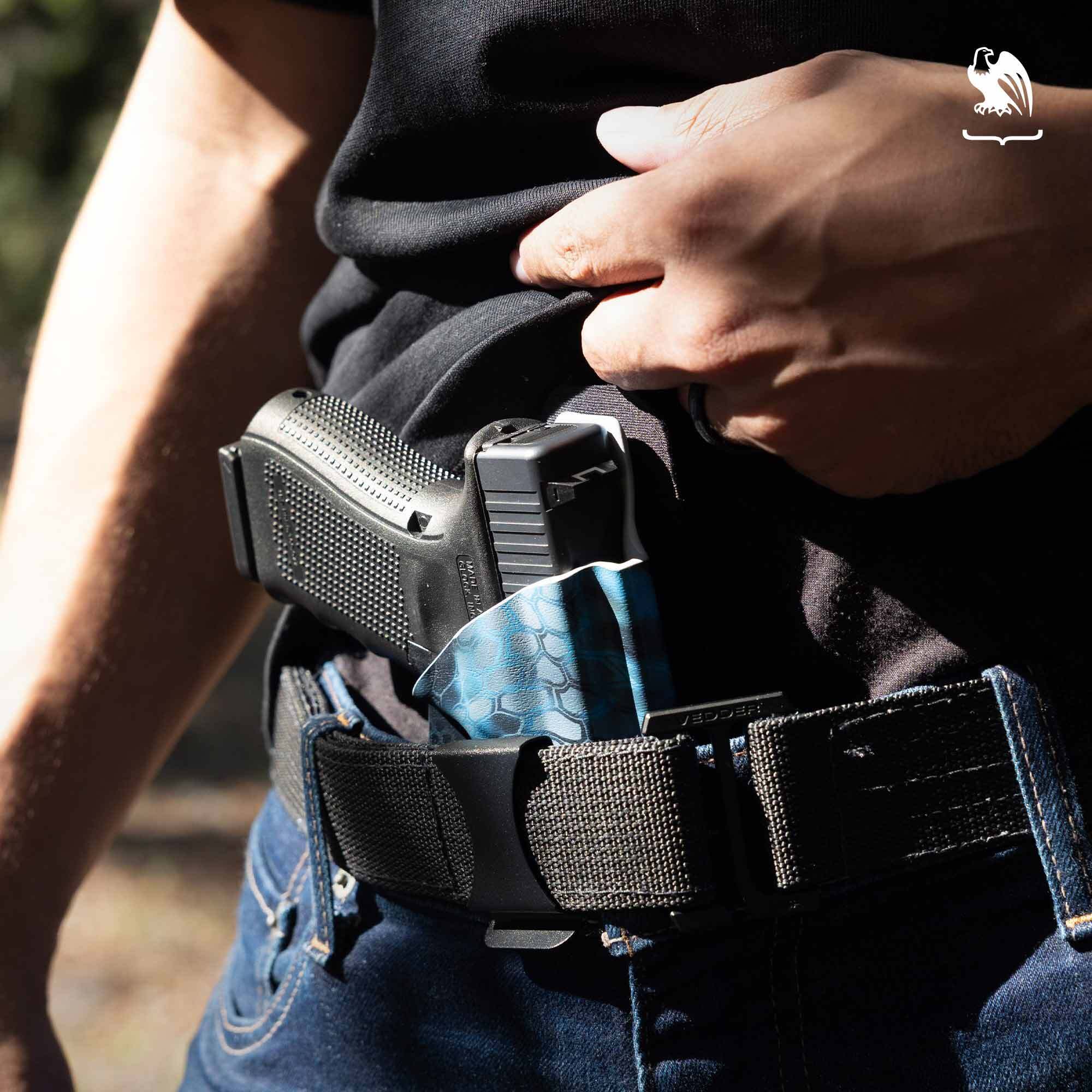 Man carrying his handgun on a IWB Holster from Vedder Holsters under jeans and a black shirt.