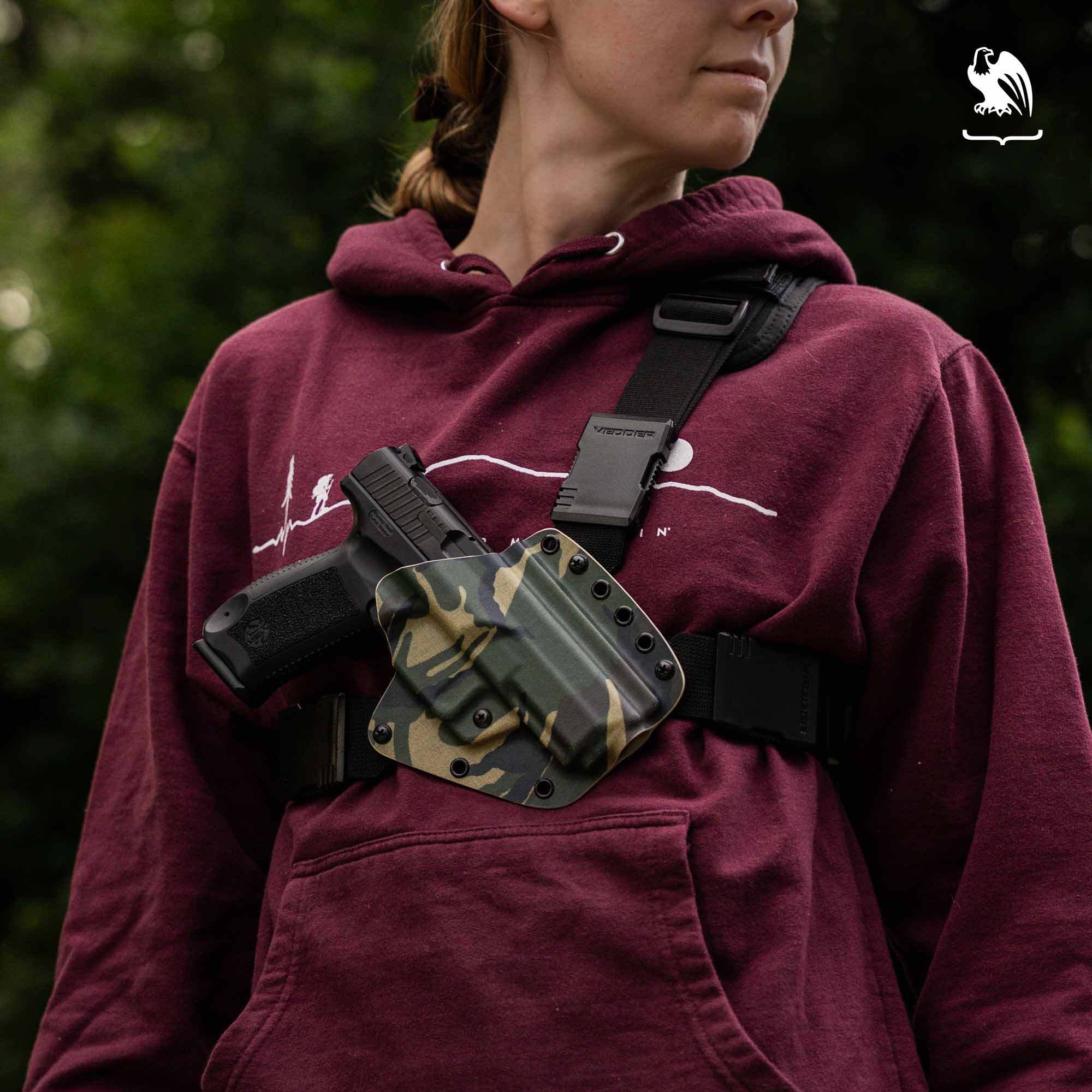 Female wearing the Evertrek chest holster outdoors on top of a red hoodie.