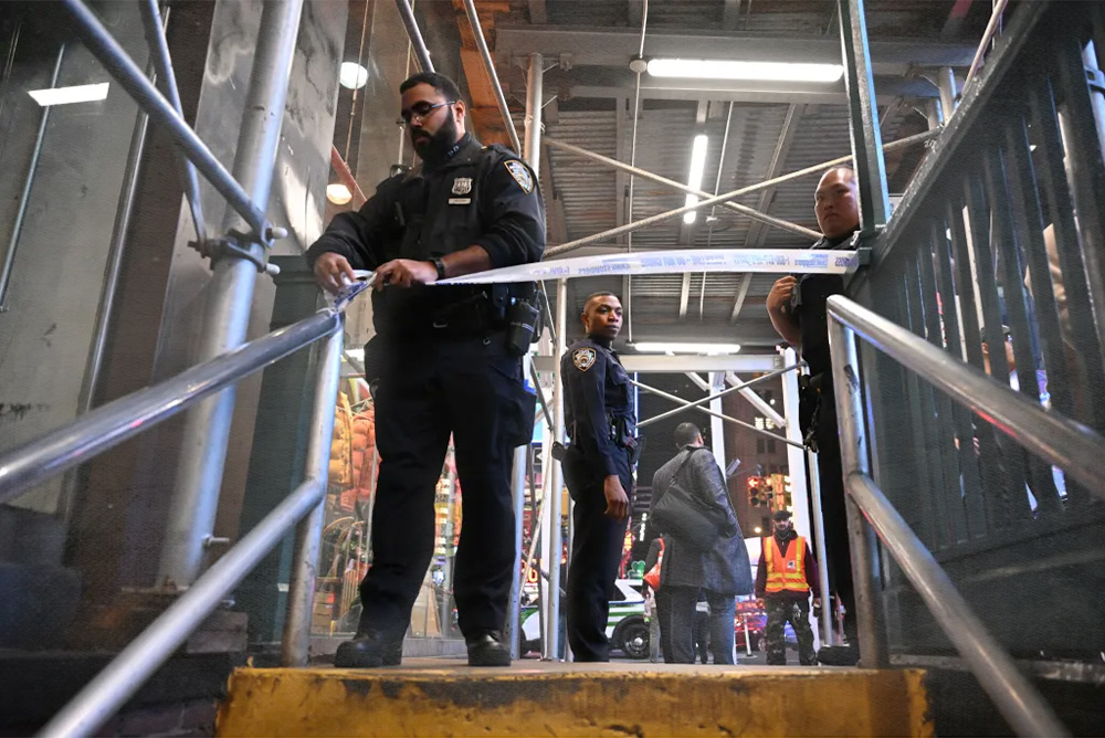 NYC Police officers closing down subway entrance with yellow tape