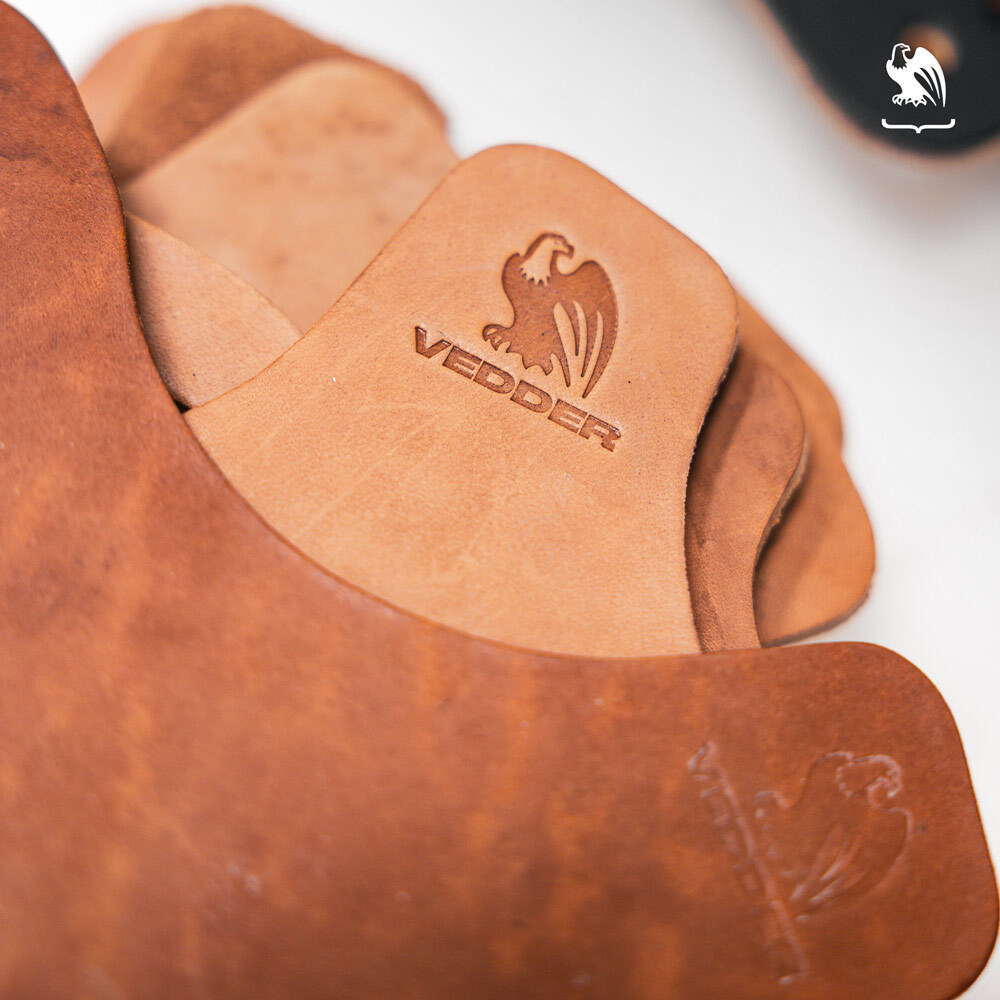 Close-up of premium Horween leather pieces stamped with the Vedder Holsters logo for handcrafted concealed carry holsters.