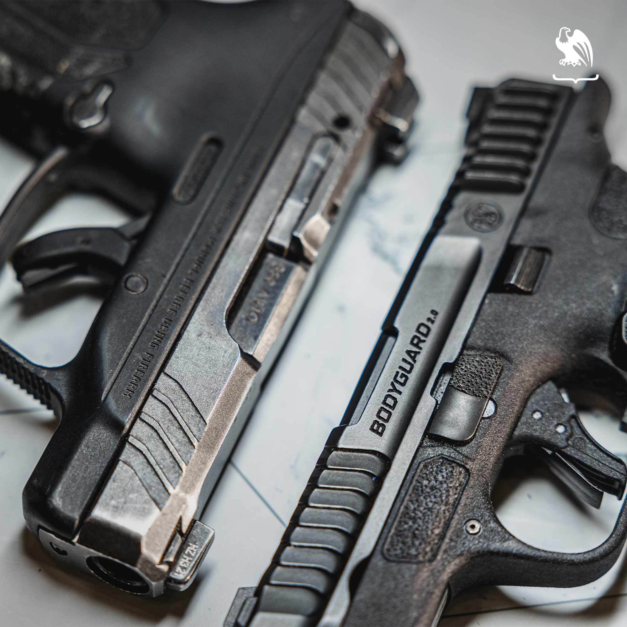 Close-up view of two compact semi-automatic handguns placed side by side, highlighting slide details, grip texture, and size commonly considered for everyday carry and personal self-defense.