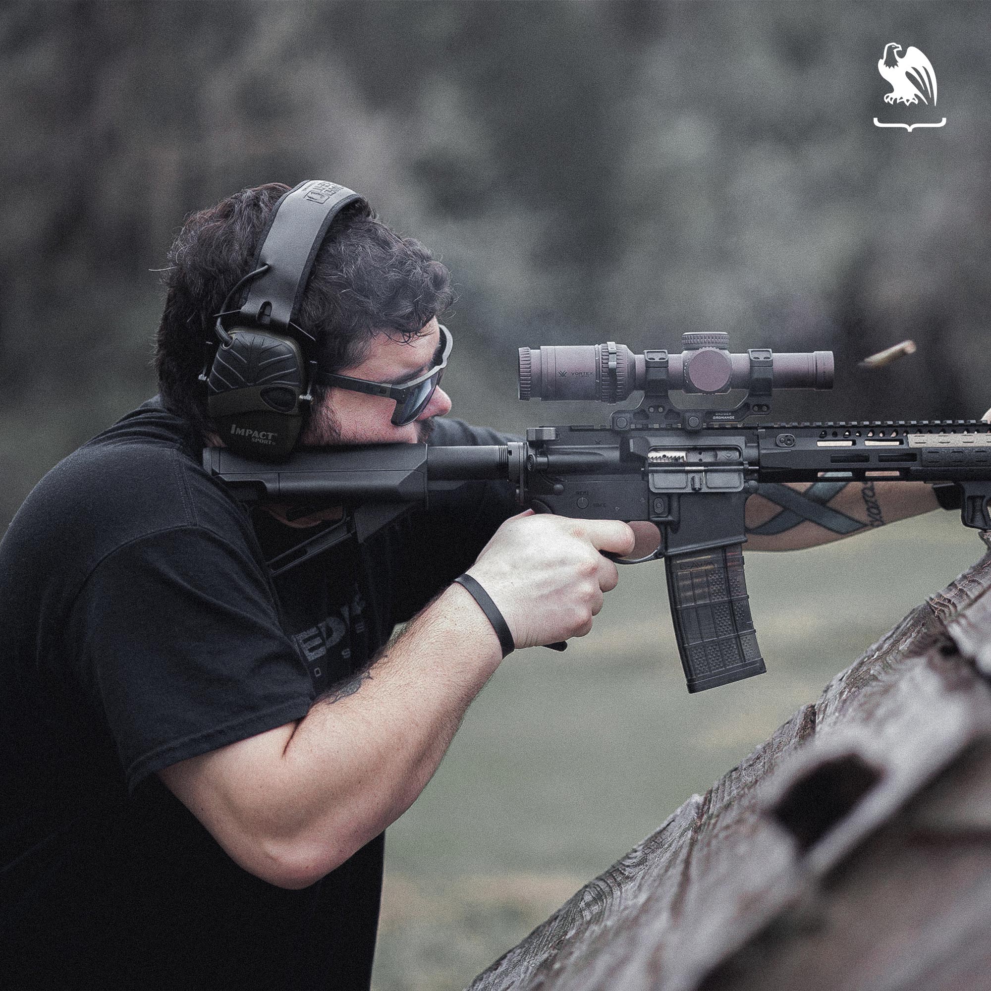 Eyewear - Man shooting a rifle at a gun range wearing eyewear for protection.