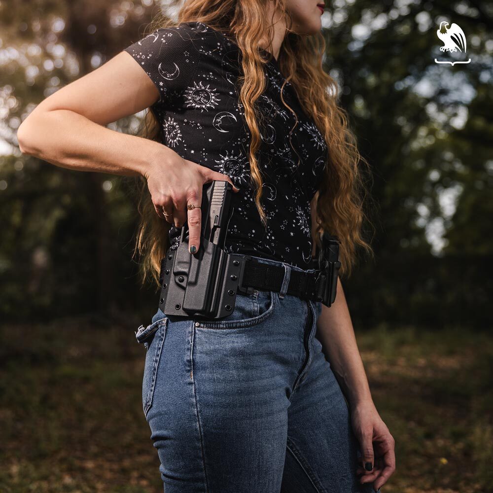 Woman standing outdoors carrying her handgun on a LightDraw OWB Kydex Holster from Vedder Holsters. 