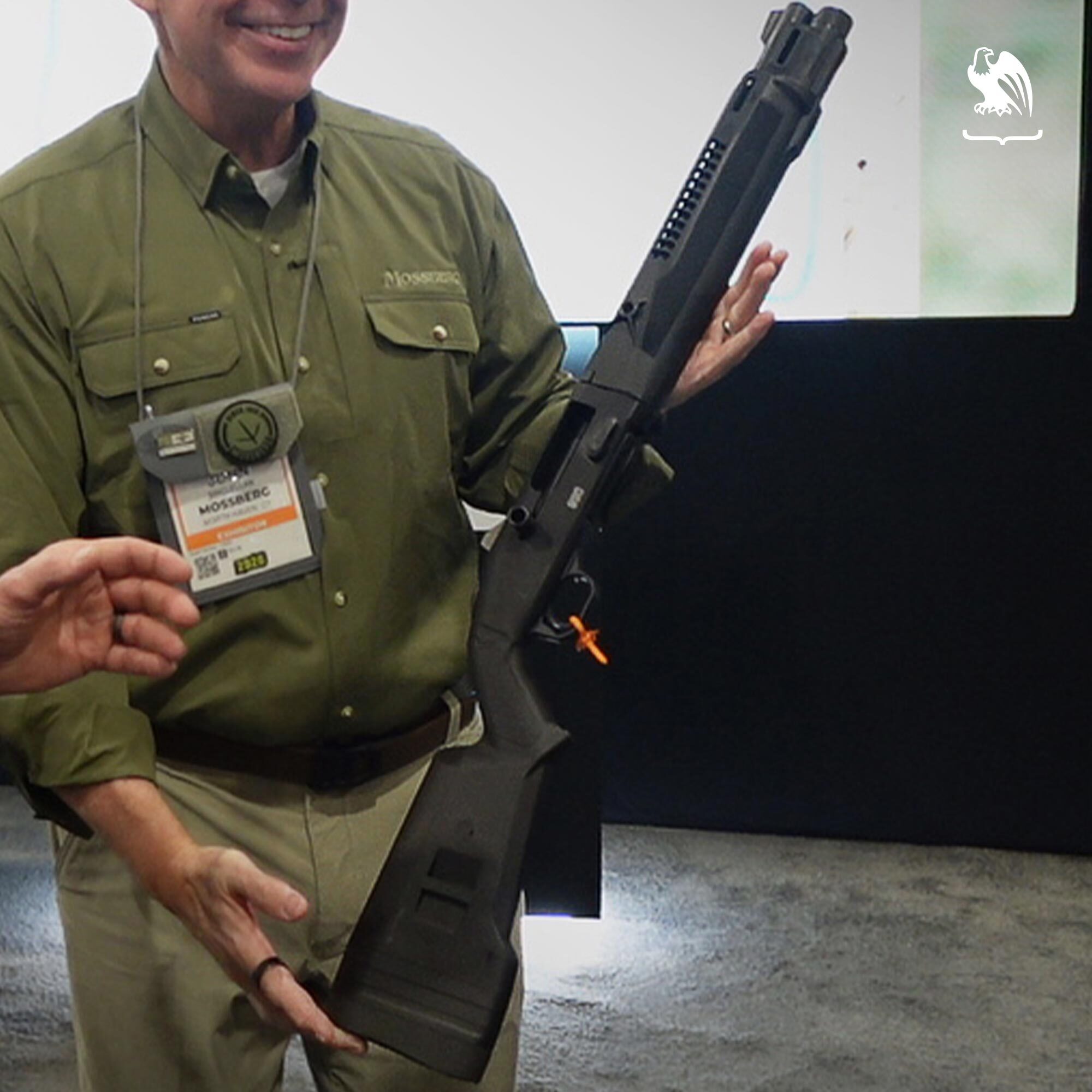 Mossberg 990 SPX short-barreled shotgun shown with an orange chamber safety flag during a SHOT Show product unveiling.
