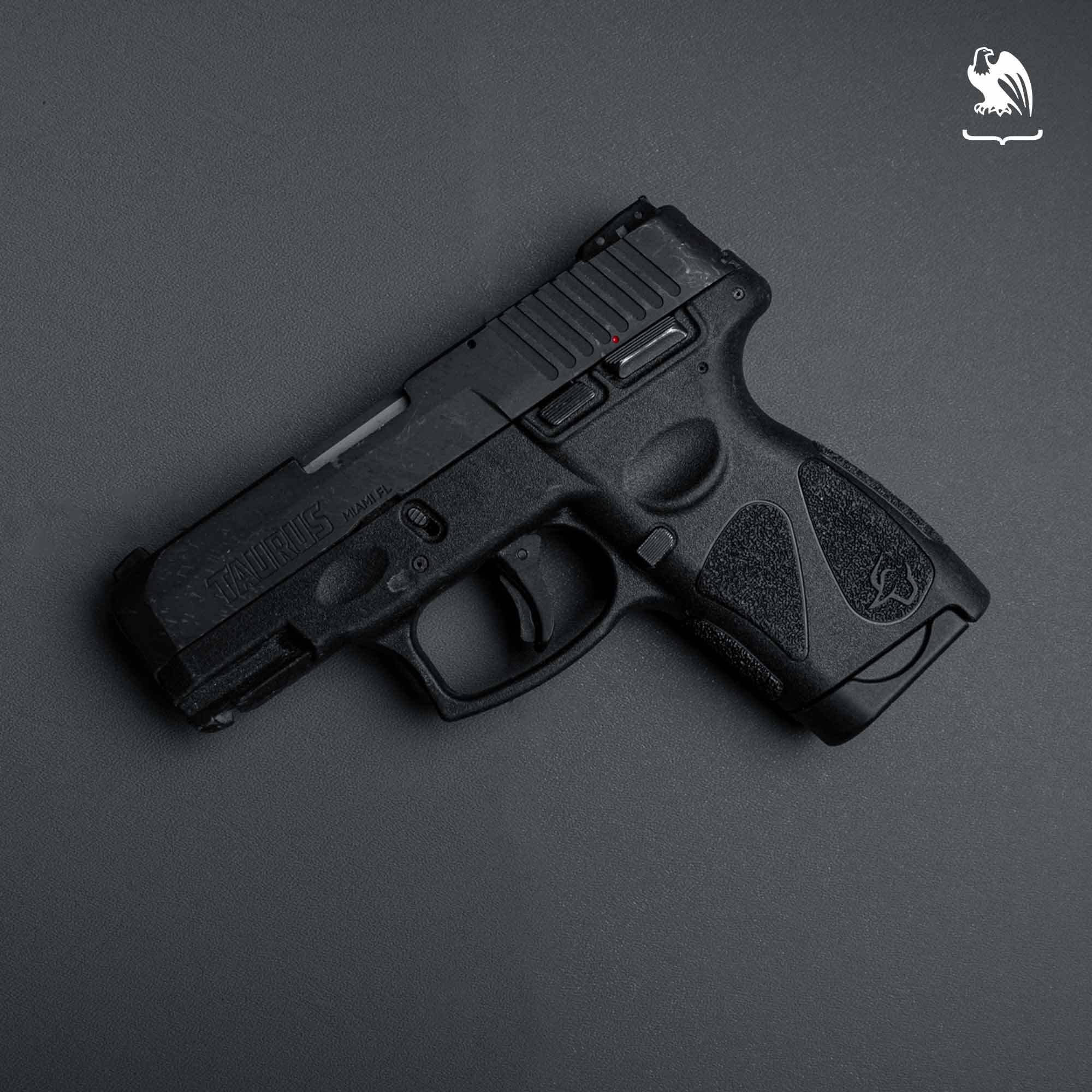 Side profile of a black Taurus G2C compact 9mm pistol showing the slide, polymer frame, and textured grip against a gray background.