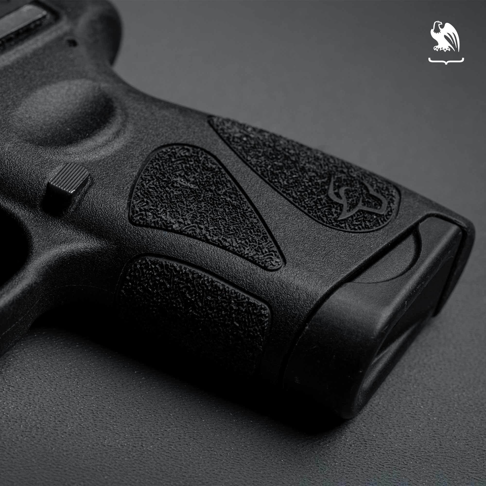 Close-up of the stippled grip texture and magazine base plate on a Taurus G2C handgun.