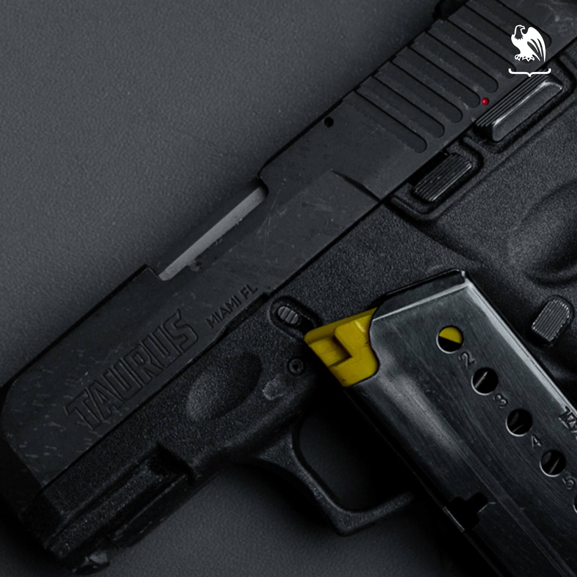 Close-up of Taurus G2C slide and frame with detached magazine and yellow follower