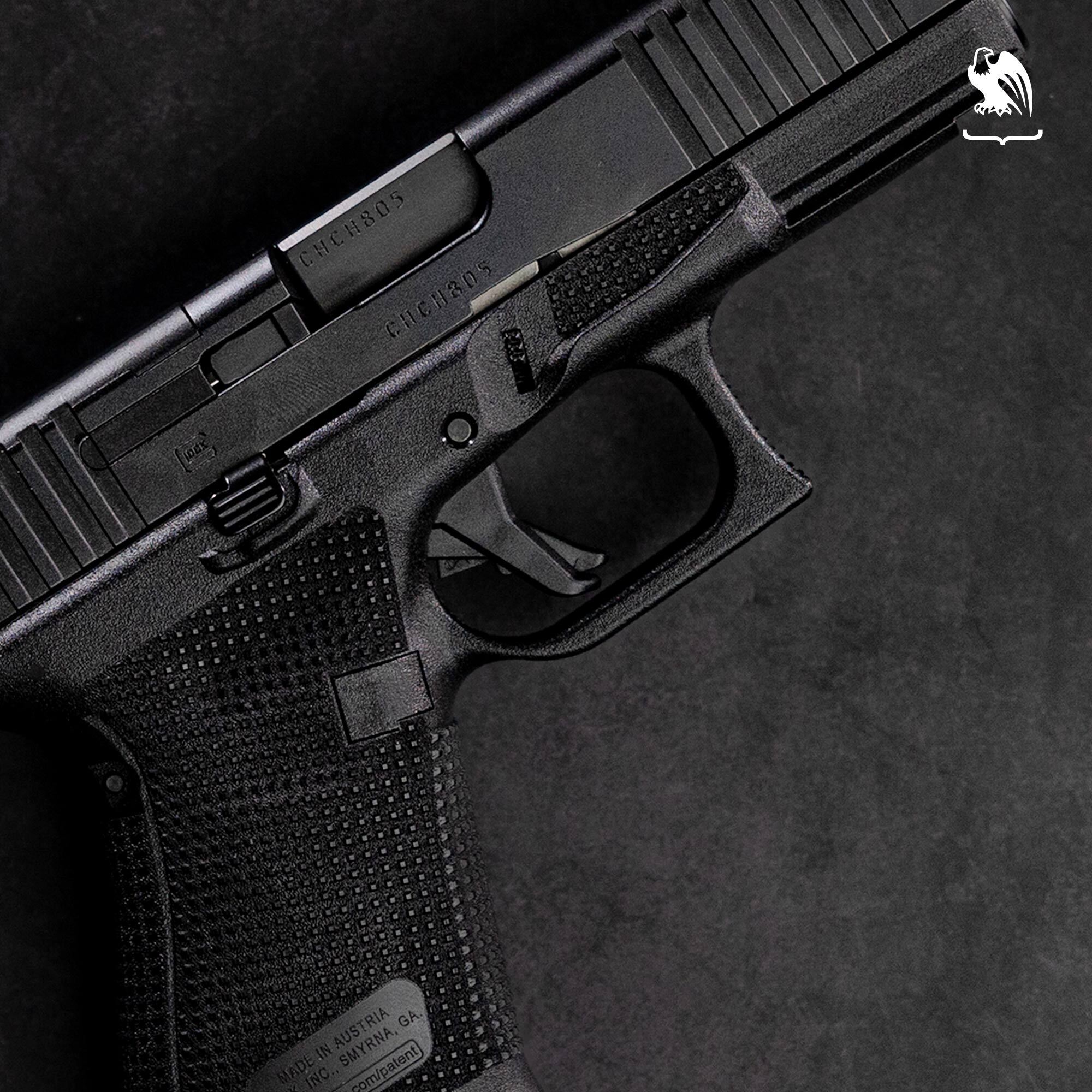 Close-up of Glock 19 trigger, trigger guard, and stippled grip on dark background