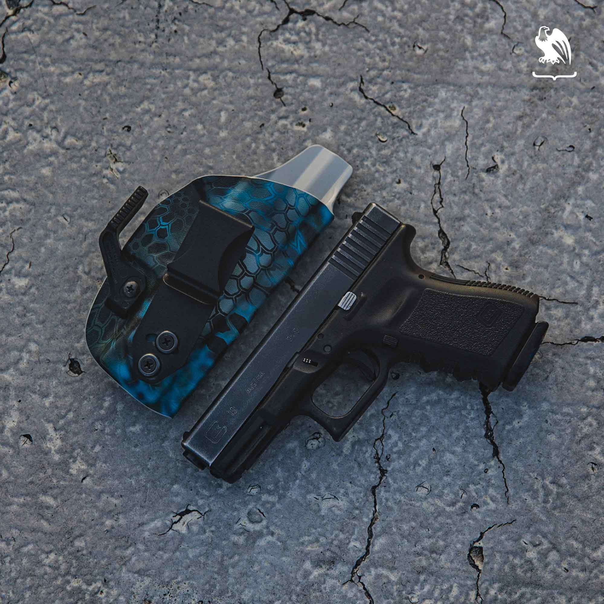 A Glock handgun paired with a Vedder Holsters LightTuck® IWB Kydex holster in a blue Kryptek pattern, designed for secure and comfortable concealed carry.