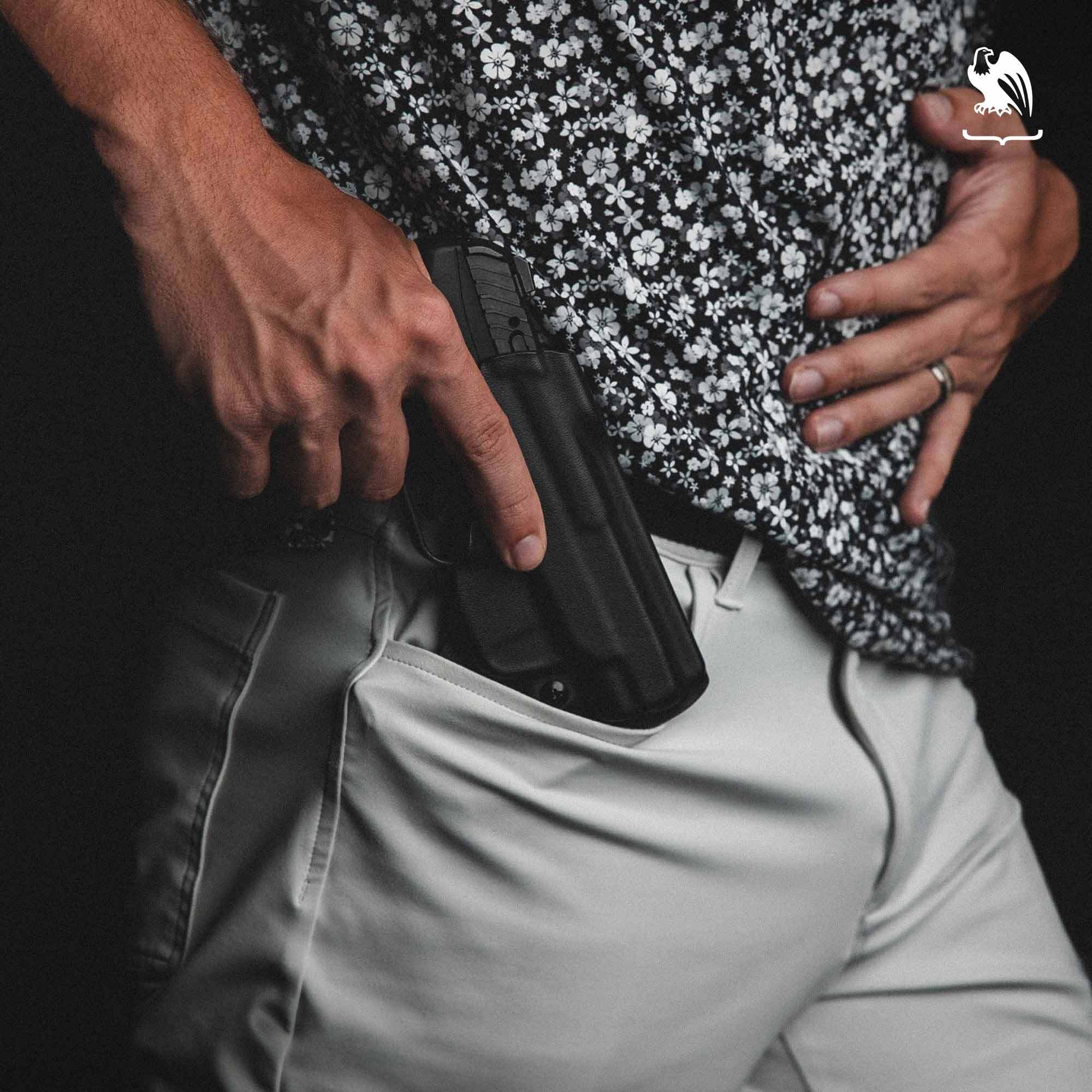 Man carrying his handgun on a pocket holster from Vedder Holsters on his front right pocket. the man is wearing a flowers shirt and white dressing pants.