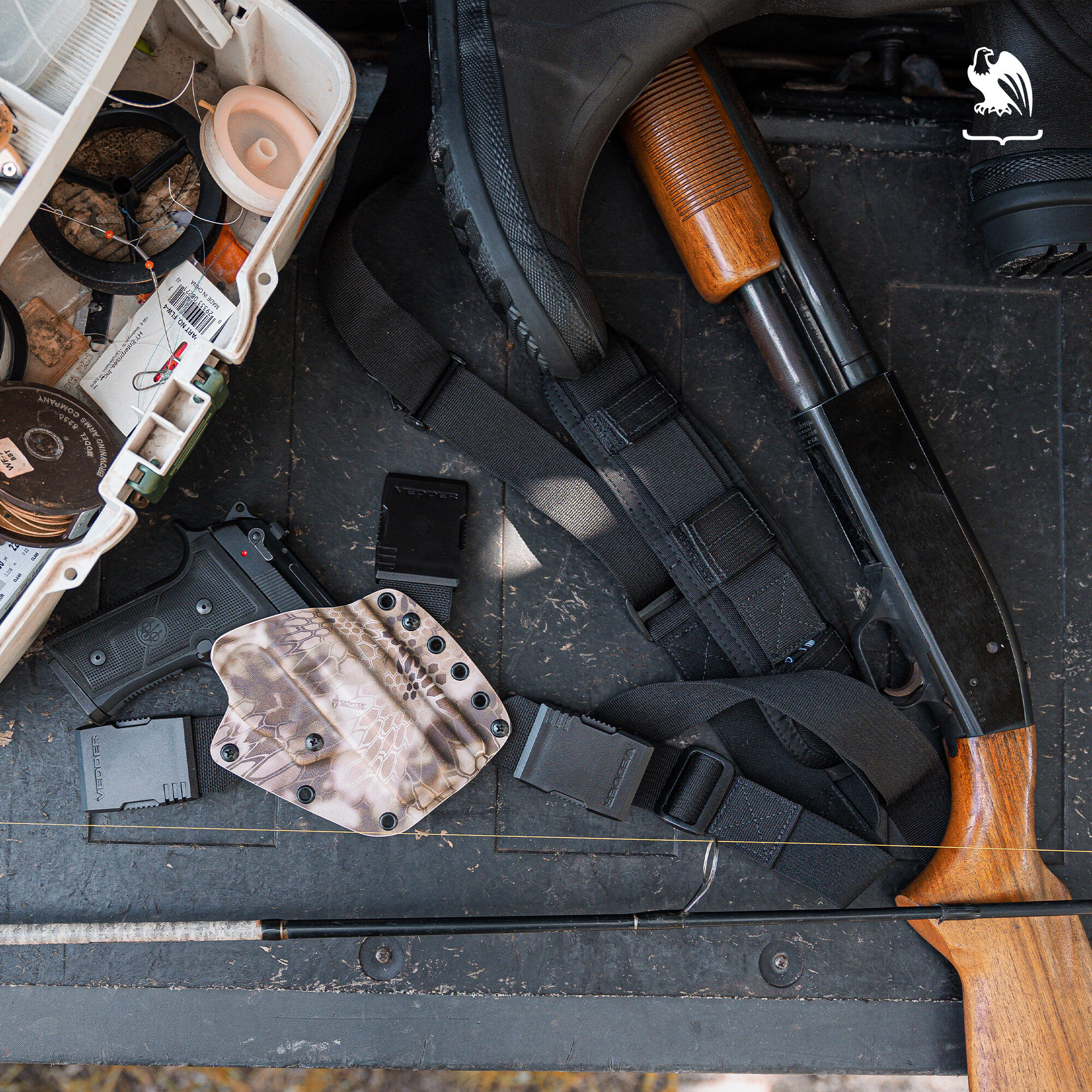 The back of a truck filled with a shotgun, a handgun on a holster from Vedder Holsters, a backpack, a boot and what looks like fishing lines.