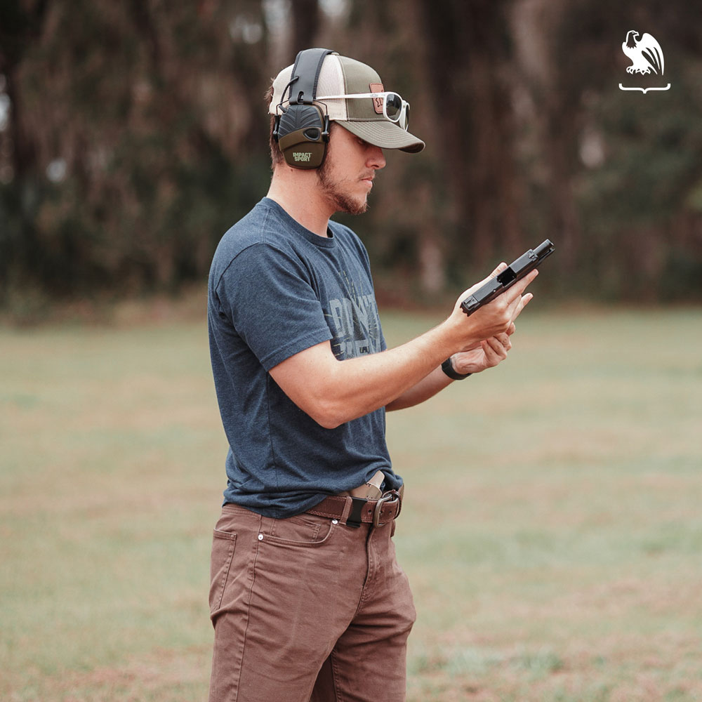 Man at a shooting range checking the handgun magazine - Limitations on Concealed Carry Coverage - Vedder Holsters Photography