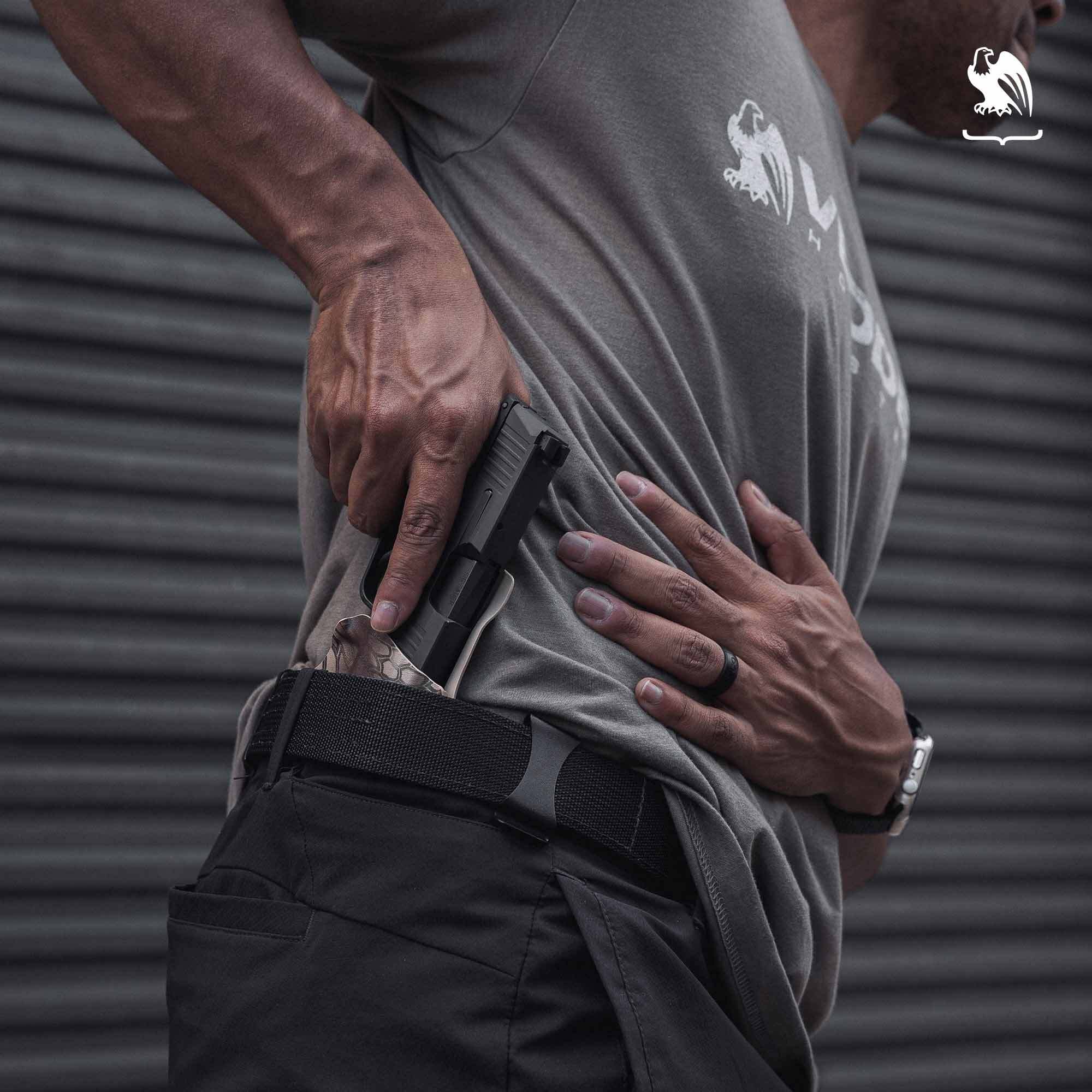 A man draws a handgun from a Vedder Holsters LightTuck® IWB Kydex holster, designed for secure and discreet concealed carry.