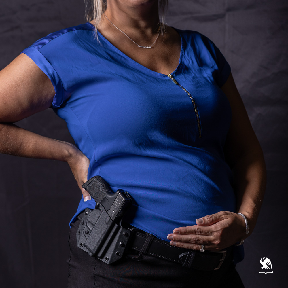 Pregnant women carrying an OWB holster from Vedder Holsters