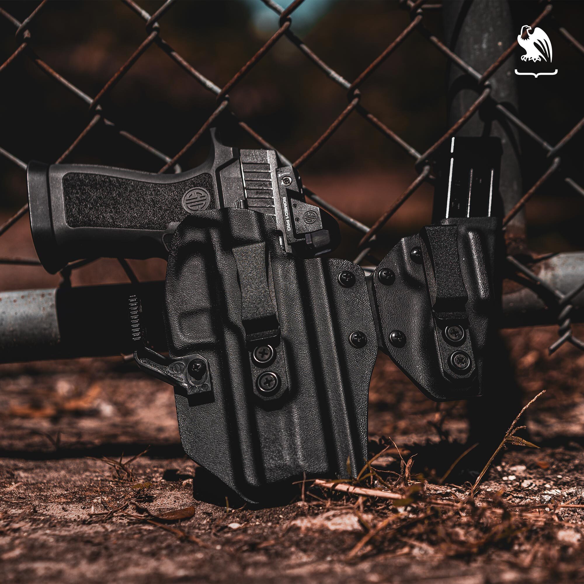 Our SideTuck IWB Kydex Holster with the Sig Sauer P320, laying against a metal fence. 