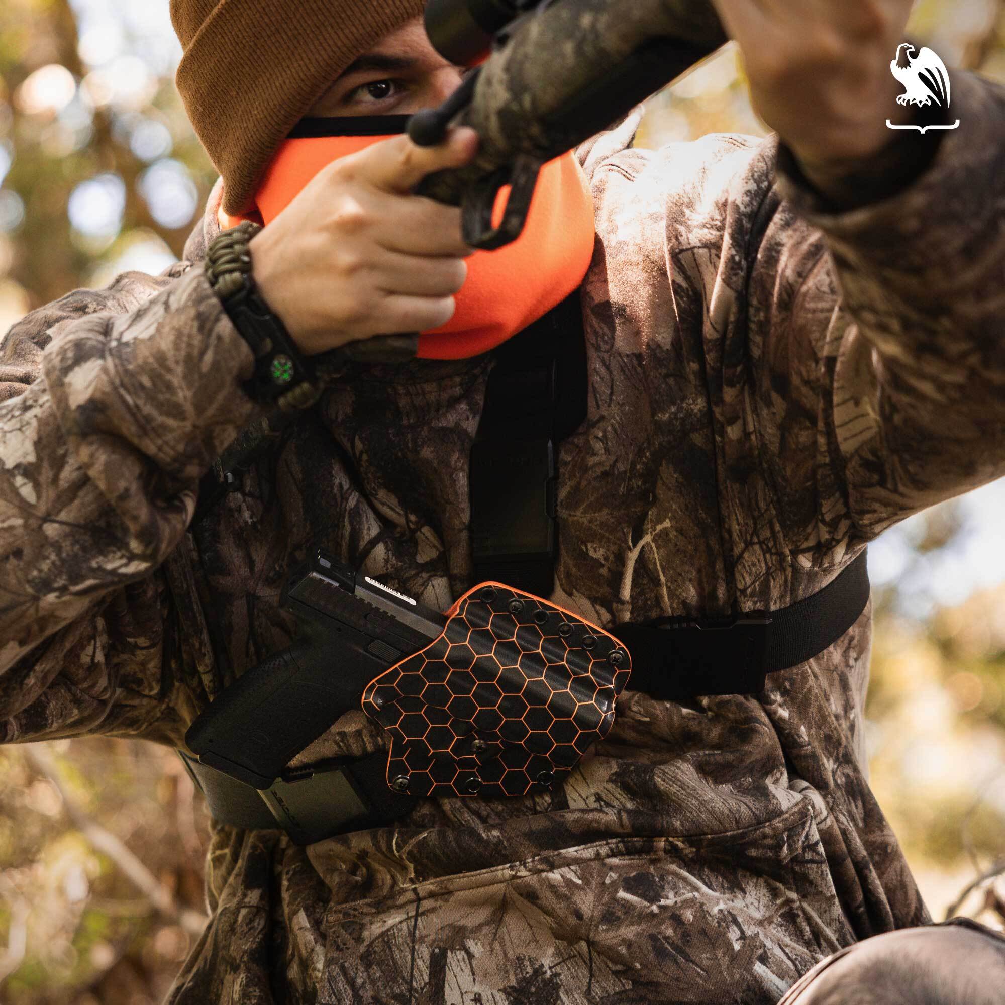 Hunter wearing camouflage and using a Vedder Holsters chest holster with a handgun while aiming a rifle.