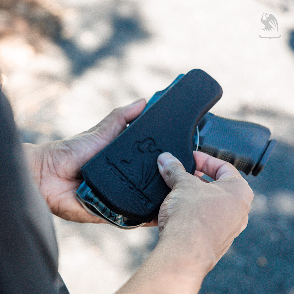 Man adjusting his comfortable HolsterPad on his Lighttuck IWB Kydex Holster outdoors. 