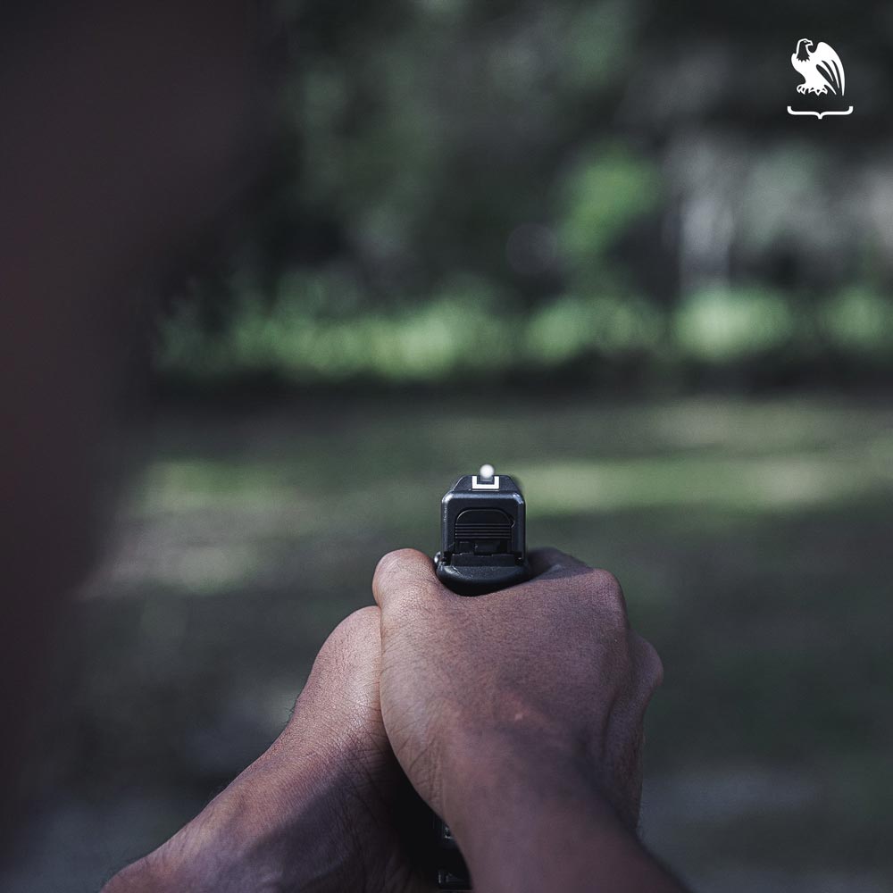 Close up photography of hands on grabbing a gun on a ready to shoot position.