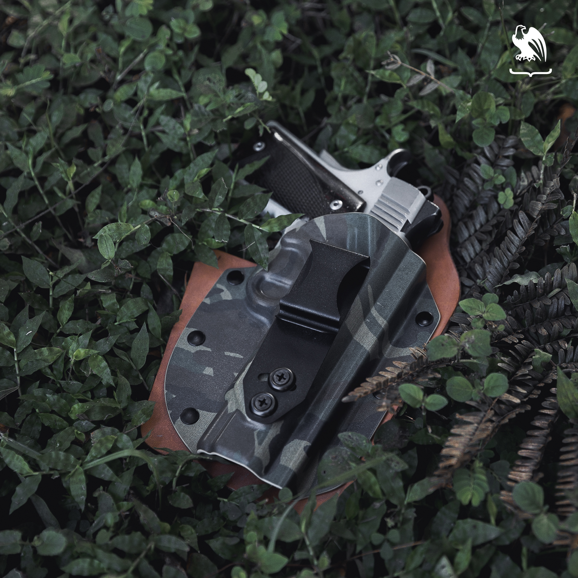 Camo colored holster from Vedder Holsters laying on the grass. 