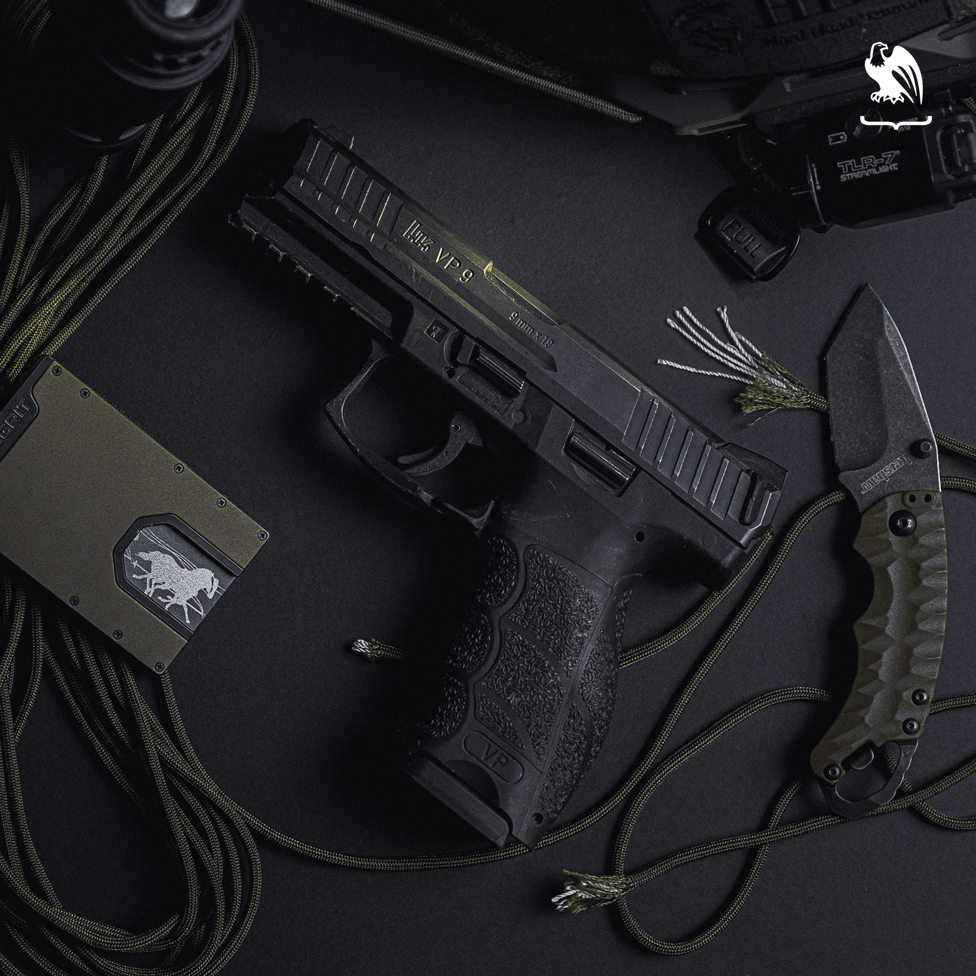 VP9 handgun laying on a table along side a Geogrit wallet and other items